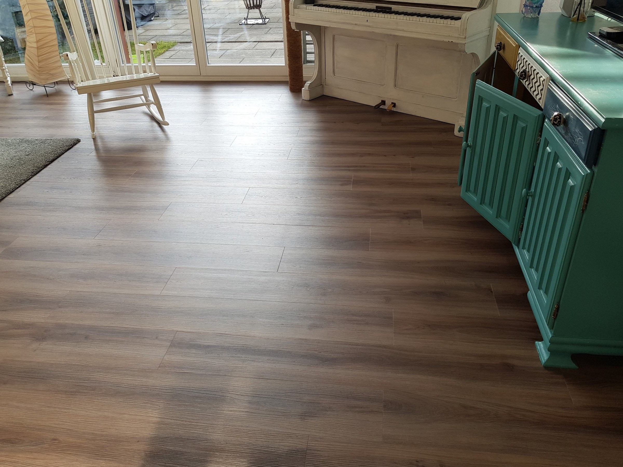 Fertig verlegter Vinylboden in einem Wohnraum mit Fenstertüren