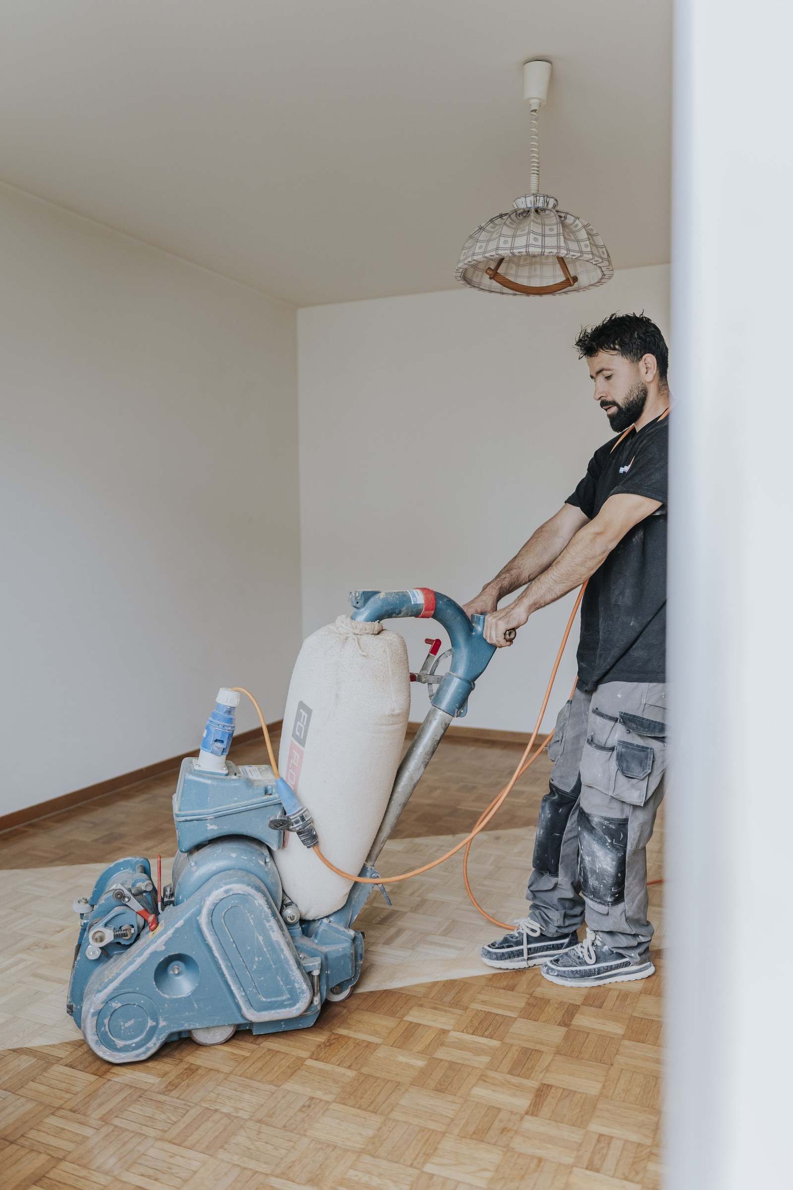 Parkett wird mit einer Schleifmaschine geschliffen