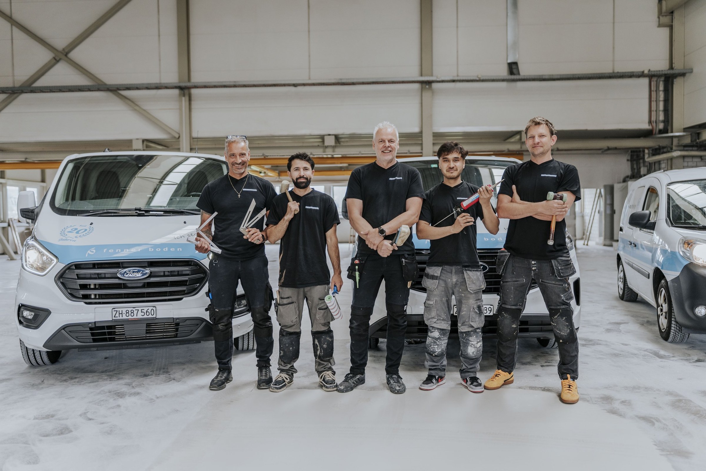 Das Team von fenner boden vor den Firmenfahrzeugen